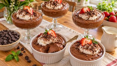 Chocolate mousse cups topped with whipped cream, shaved chocolate and strawberries