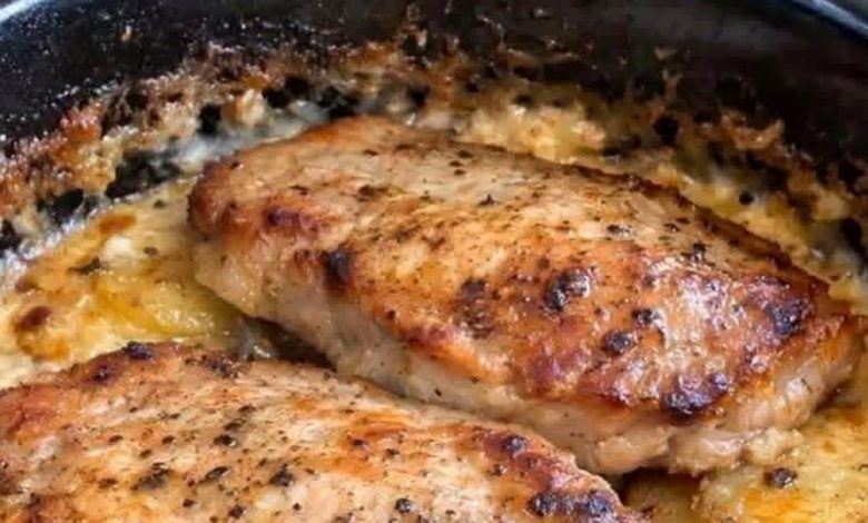 Slow cooker pork chops on creamy potatoes in a black crock