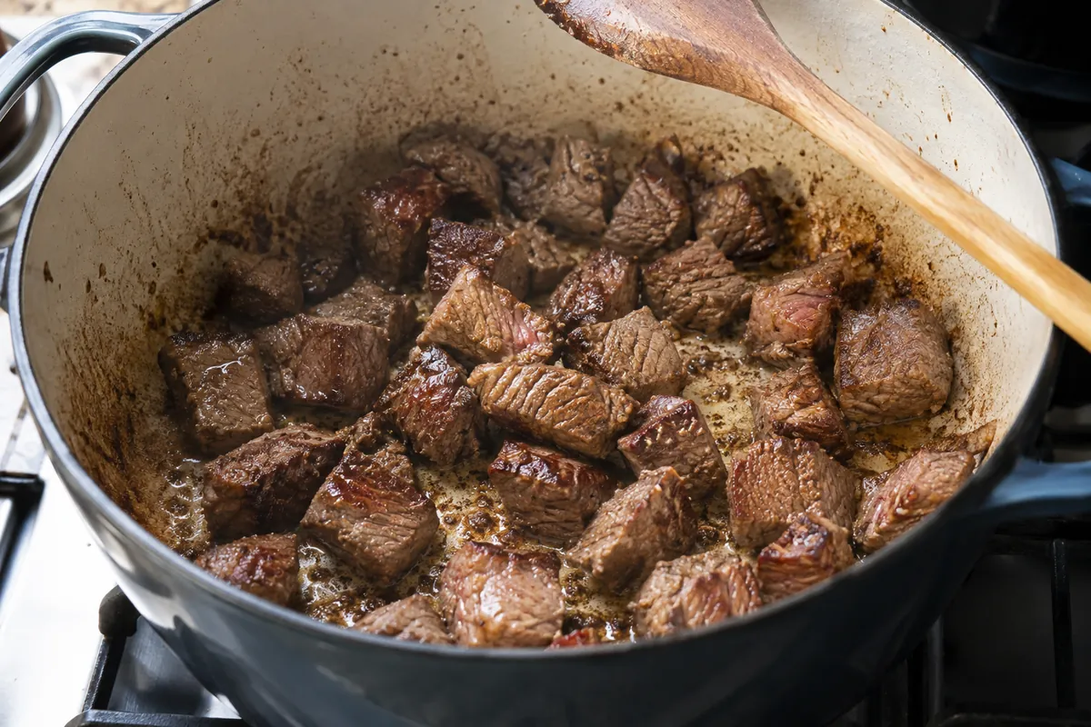 Beef cubes searing in a Dutch oven for green chile stew