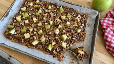 Caramel apple pretzel bark with chocolate, diced green apple, caramel drizzle and sea salt on parchment
