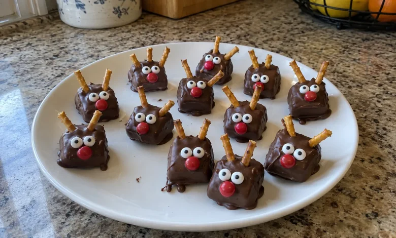 Plate of finished chocolate caramel reindeer with pretzel antlers, candy eyes and red noses