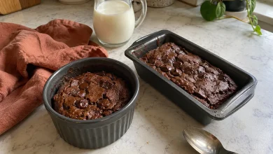 Cottage cheese brownie for one in a small dark ceramic ramekin and a mini loaf pan on a cream marble-look counter