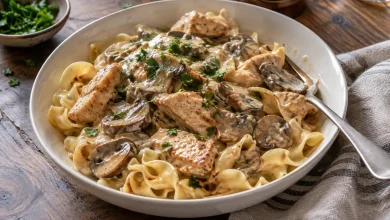 Bowl of creamy chicken mushroom stroganoff over egg noodles topped with chopped parsley