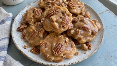 Pile of glossy creole creamy pralines studded with pecans on a plate